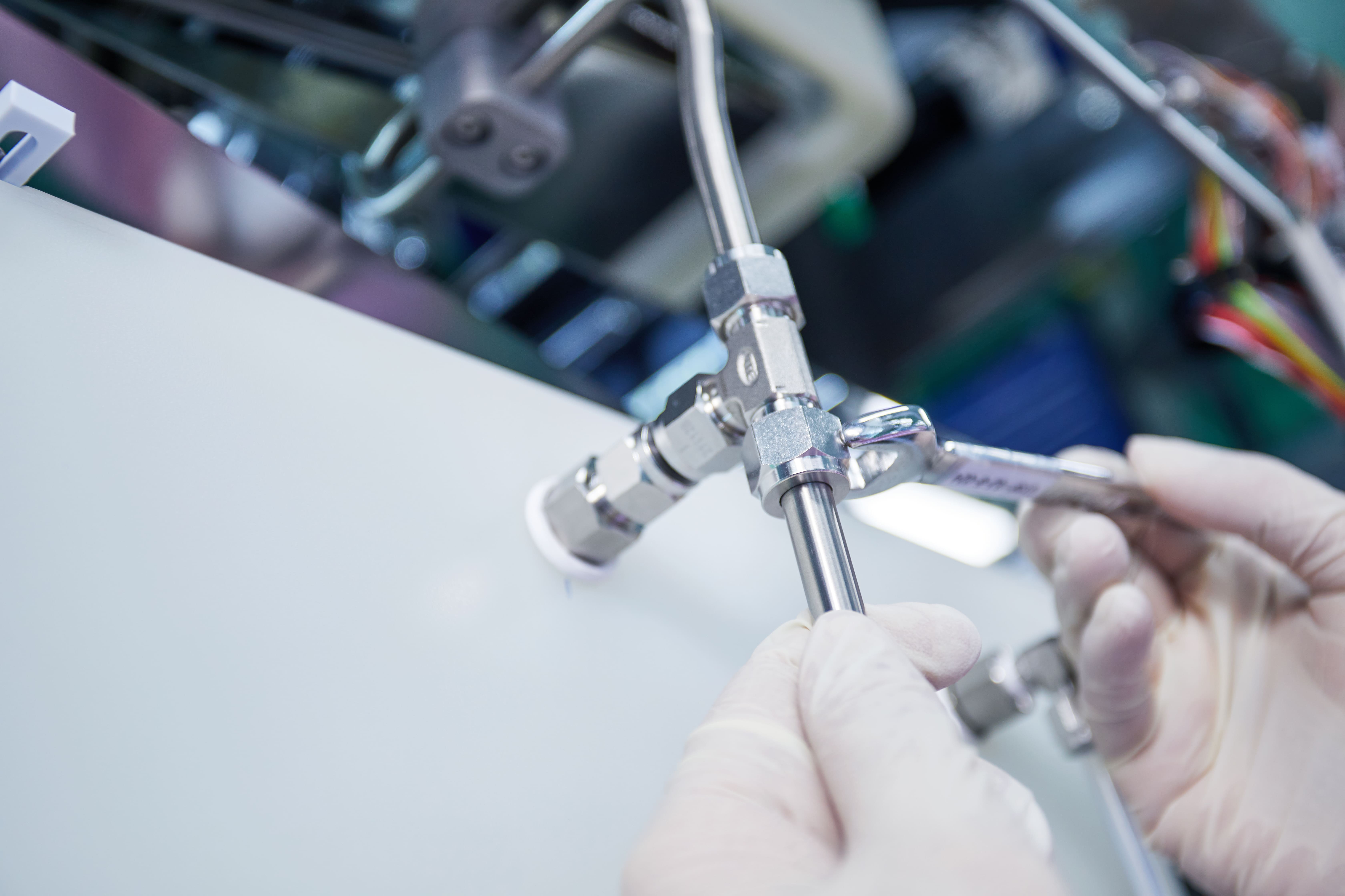 Technician assembling JPE stainless steel tube fittings with a torque wrench to guarantee sealing integrity and high-pressure reliability in fluid systems.