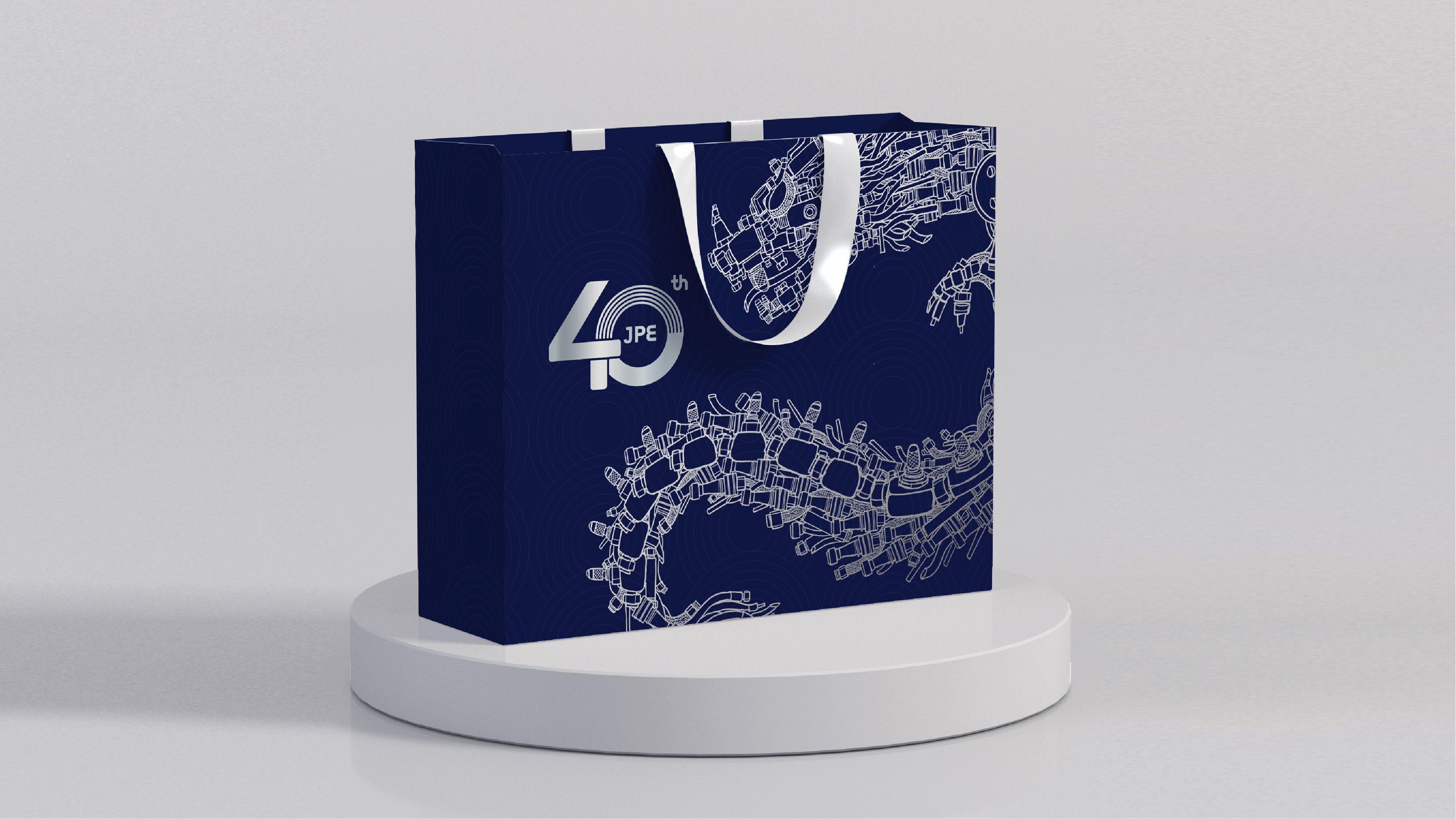 JPE 40周年纪念手提袋,以金属蓝底与飞龙线稿设计呈现品牌主视觉,展现企业坚韧与荣耀。