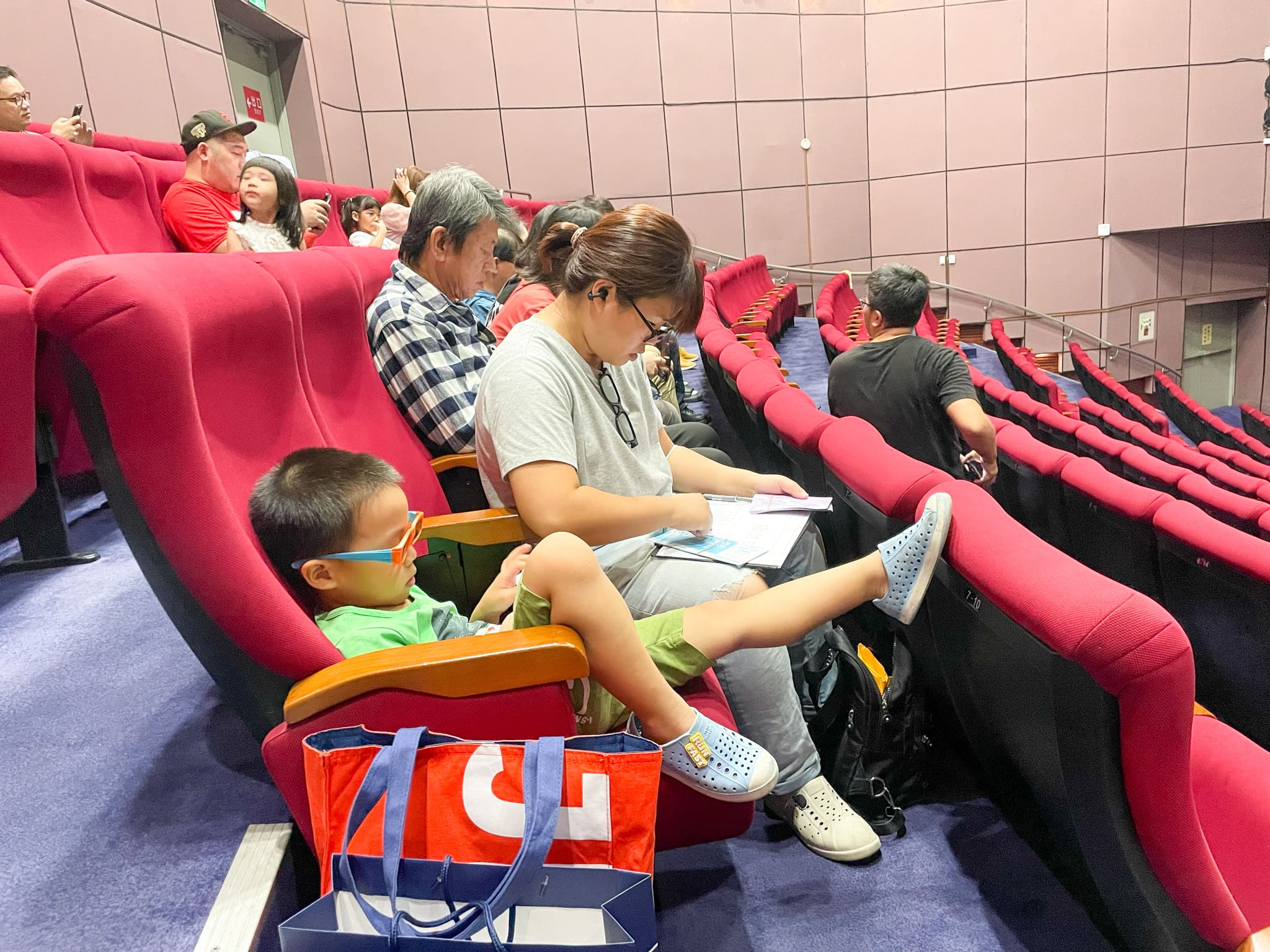 JPE沅亨科工館親子日活動中，家長與孩子在科工館電影院入座觀賞3D科普影片的情景。