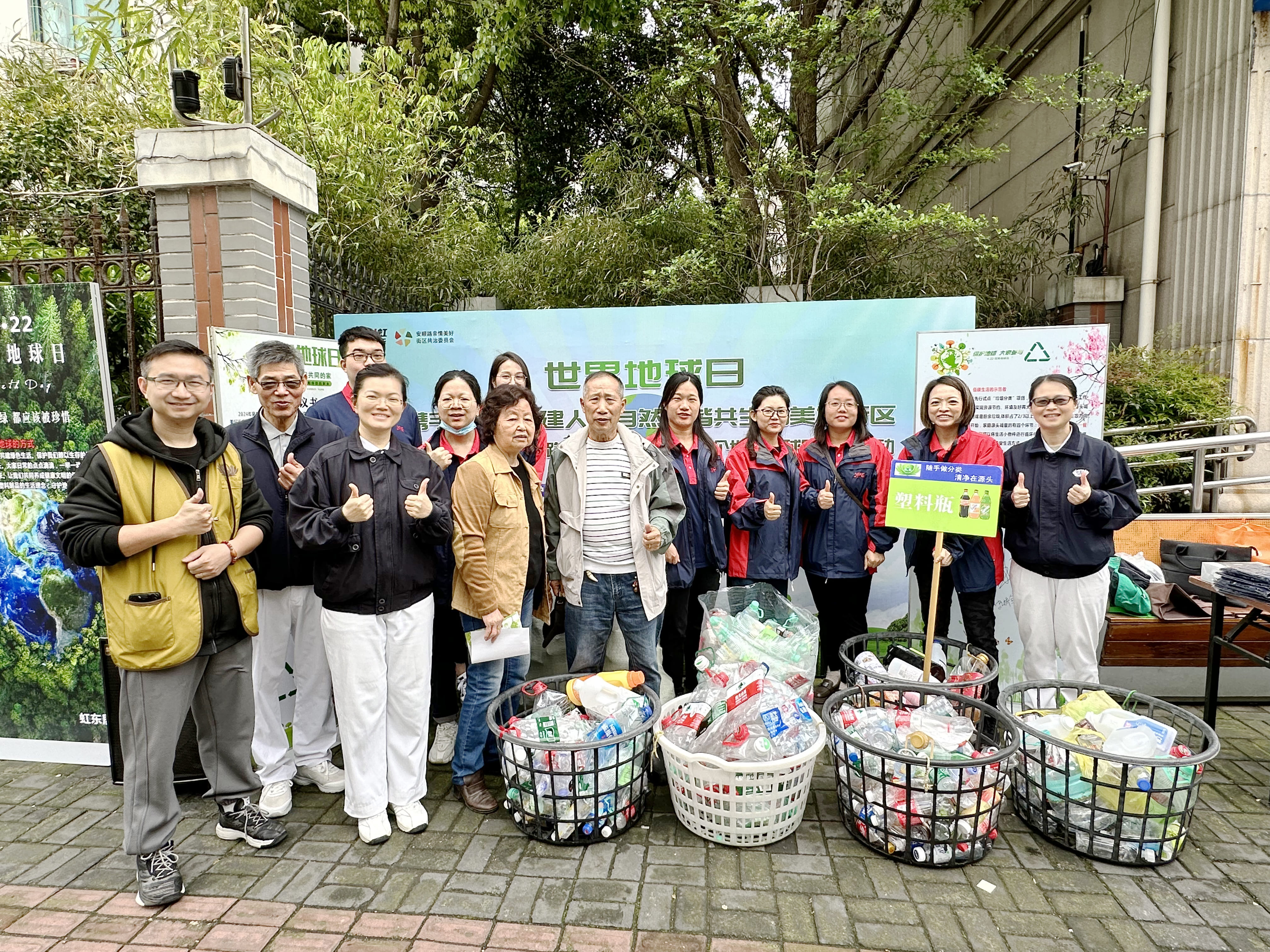 JPE昆山團隊於上海長寧區社區地球日環保活動合照，前方放置分類後的塑料瓶與回收物。