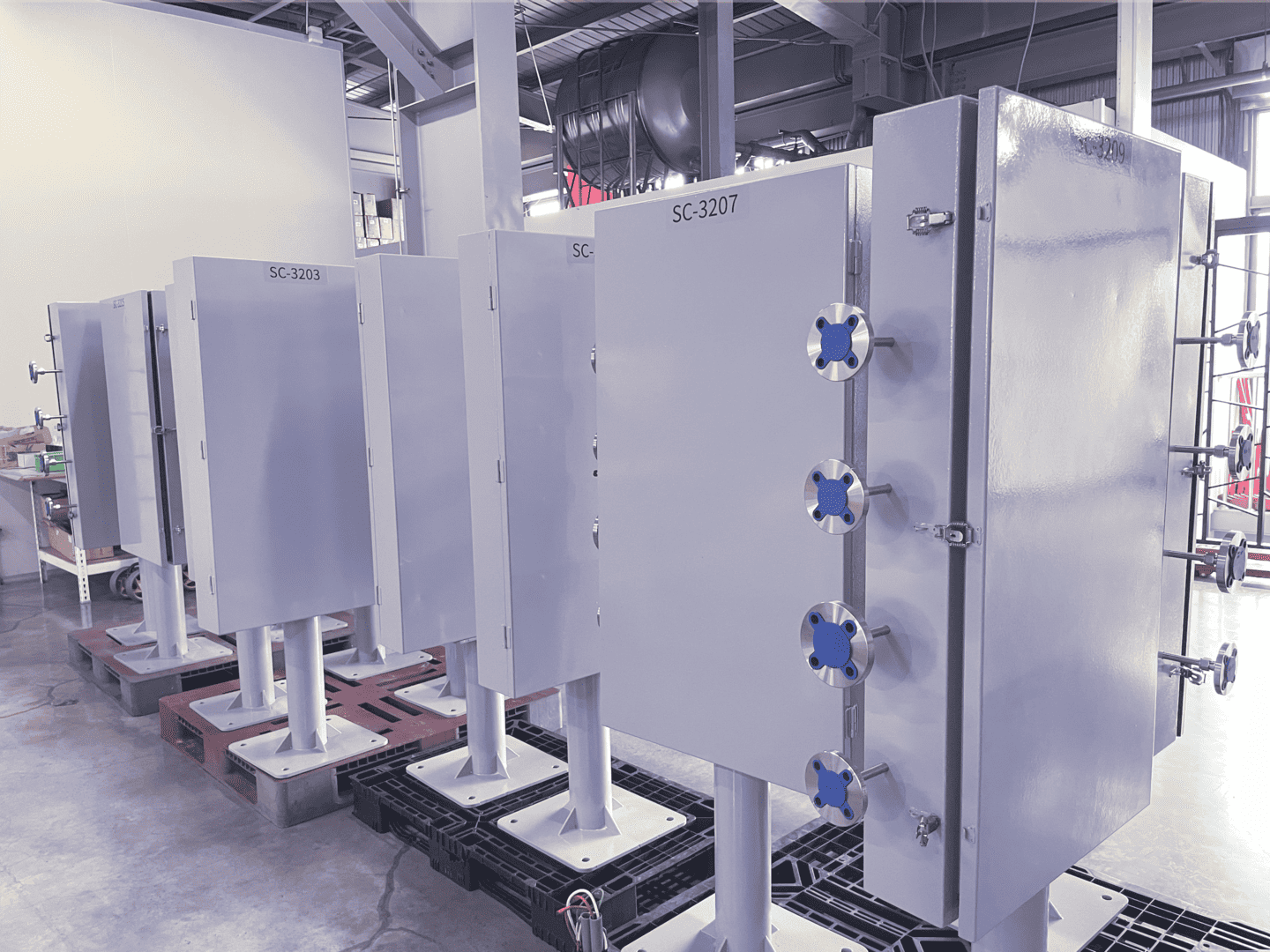 Rows of JPE petrochemical sampling system cabinets arranged in the factory, ready for inspection or delivery.