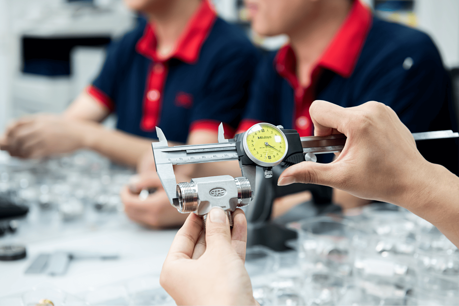 JPE 技術人員使用卡尺量測不鏽鋼接頭以確保製程品質