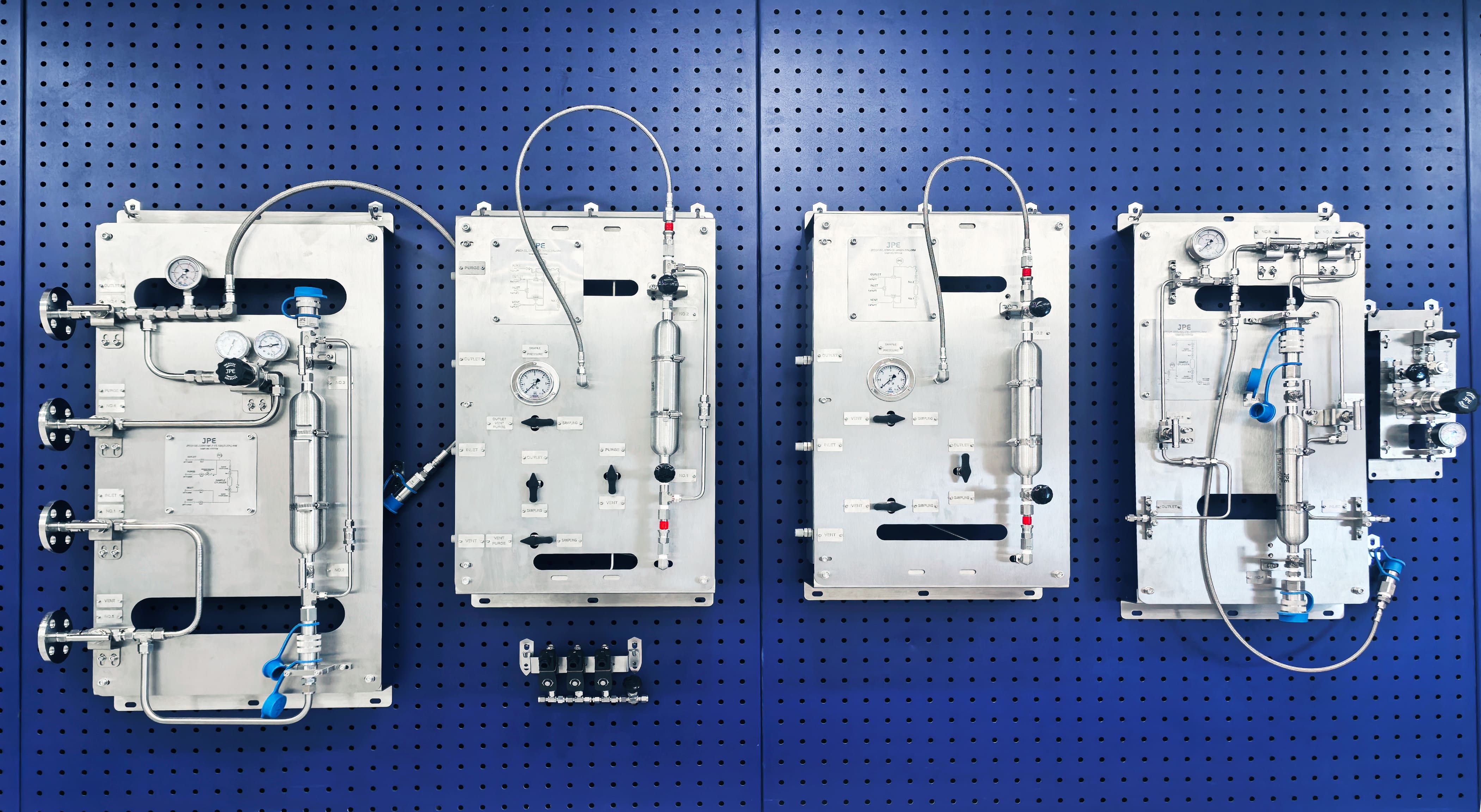 JPE sampling system display panels with stainless steel sampling modules, pressure gauges, and tubing layout