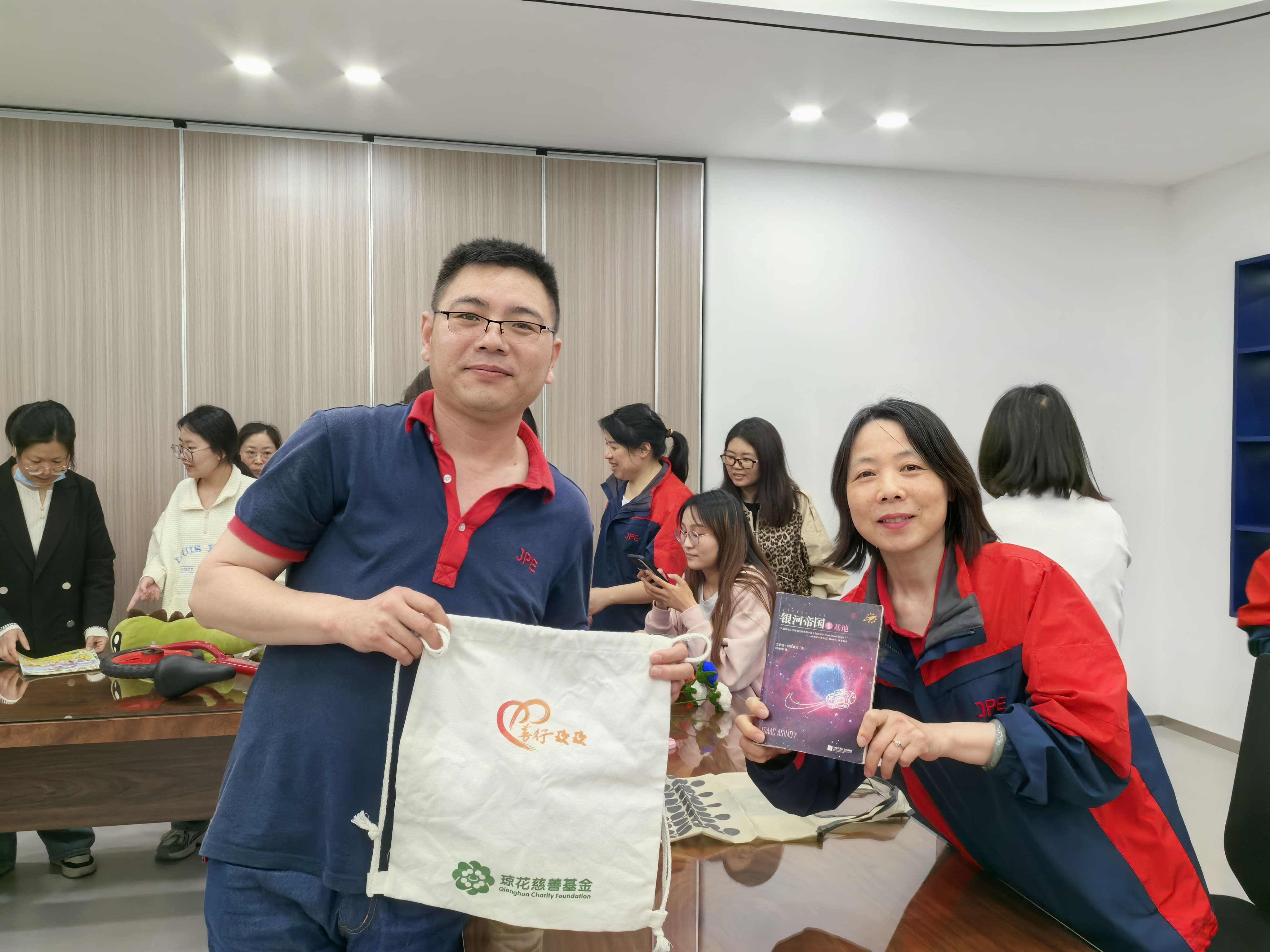 JPE Kunshan employees showcasing exchanged items and eco gifts during the second-hand swap event.