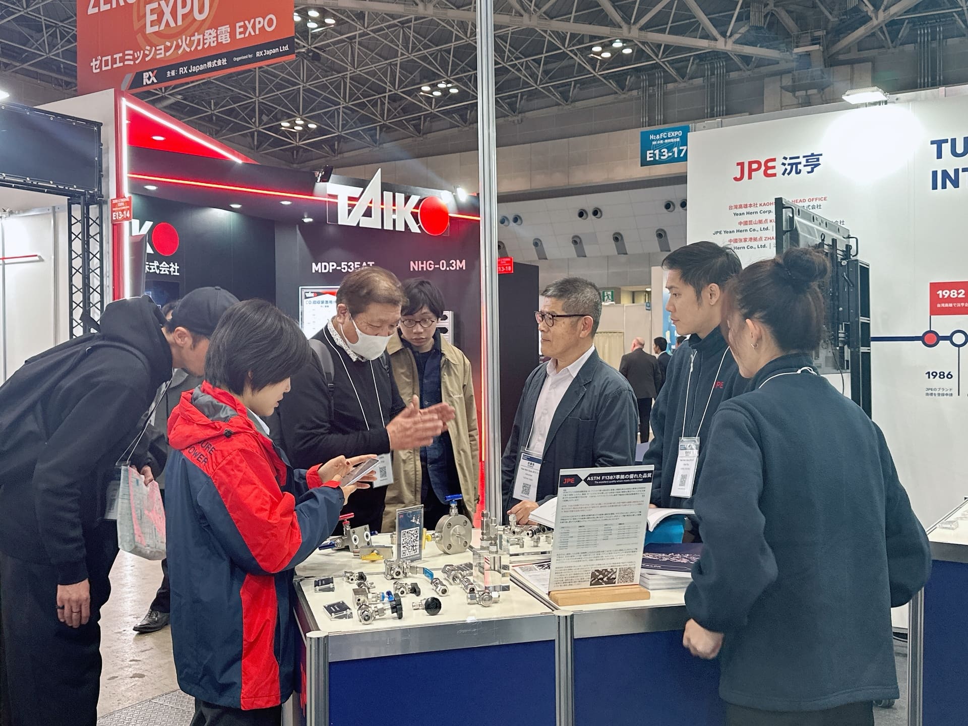 JPE於日本氫能展現場與來訪者進行產品交流，展示高壓氫能應用的閥件與接頭。